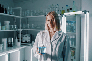 Sorgfältige Herstellung in Deutschland – kolloidales Mangan mit höchster Reinheit und Präzision Laborantin prüft Glas mit kolloidalem Mangan im deutschen Reinlabor